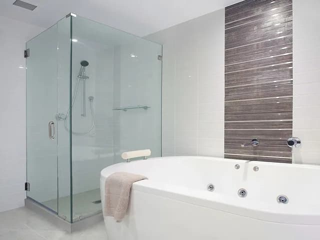 Custom glass shower doors in a modern bathroom with a freestanding tub
