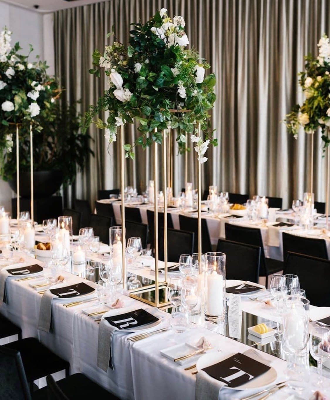 Elegant dining setup featuring custom glass table tops and floral arrangements