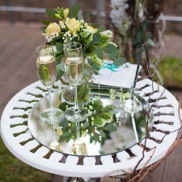 Custom glass table top reflecting champagne glasses and flowers