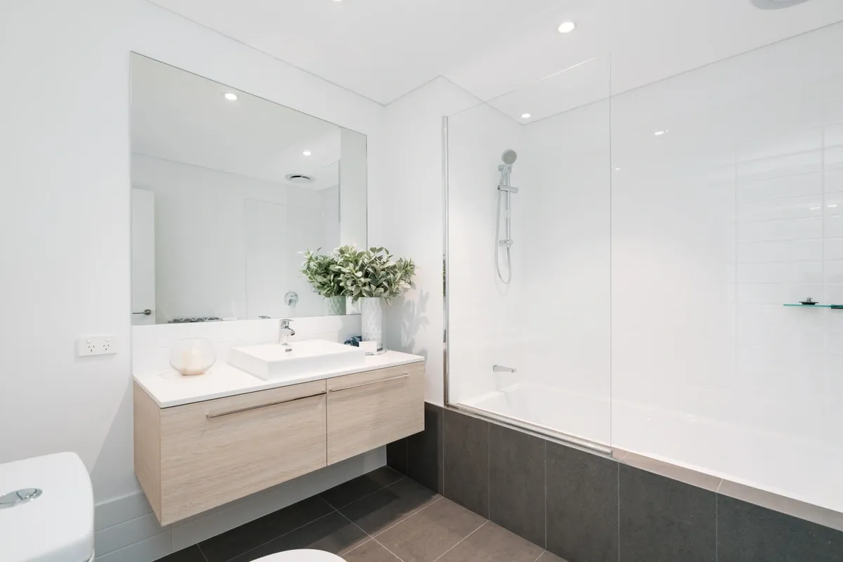 Large rectangle mirror above sink in bathroom with shower, white minimalist color theme