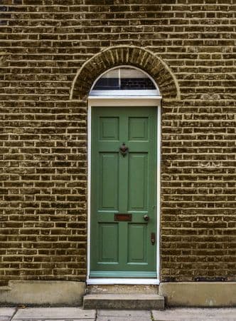 A green front door with an arched window above it
