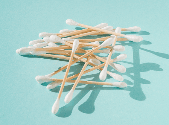 Scattered cotton swabs on a light blue background