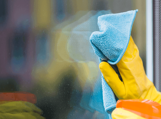 Person cleaning glass surface with a microfiber cloth