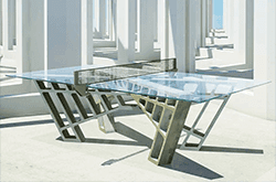 Modern glass table top featuring custom tempered glass and a unique architectural base
