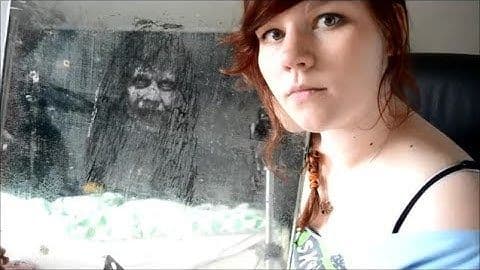 A person gazes at a misty glass surface showing an eerie reflection