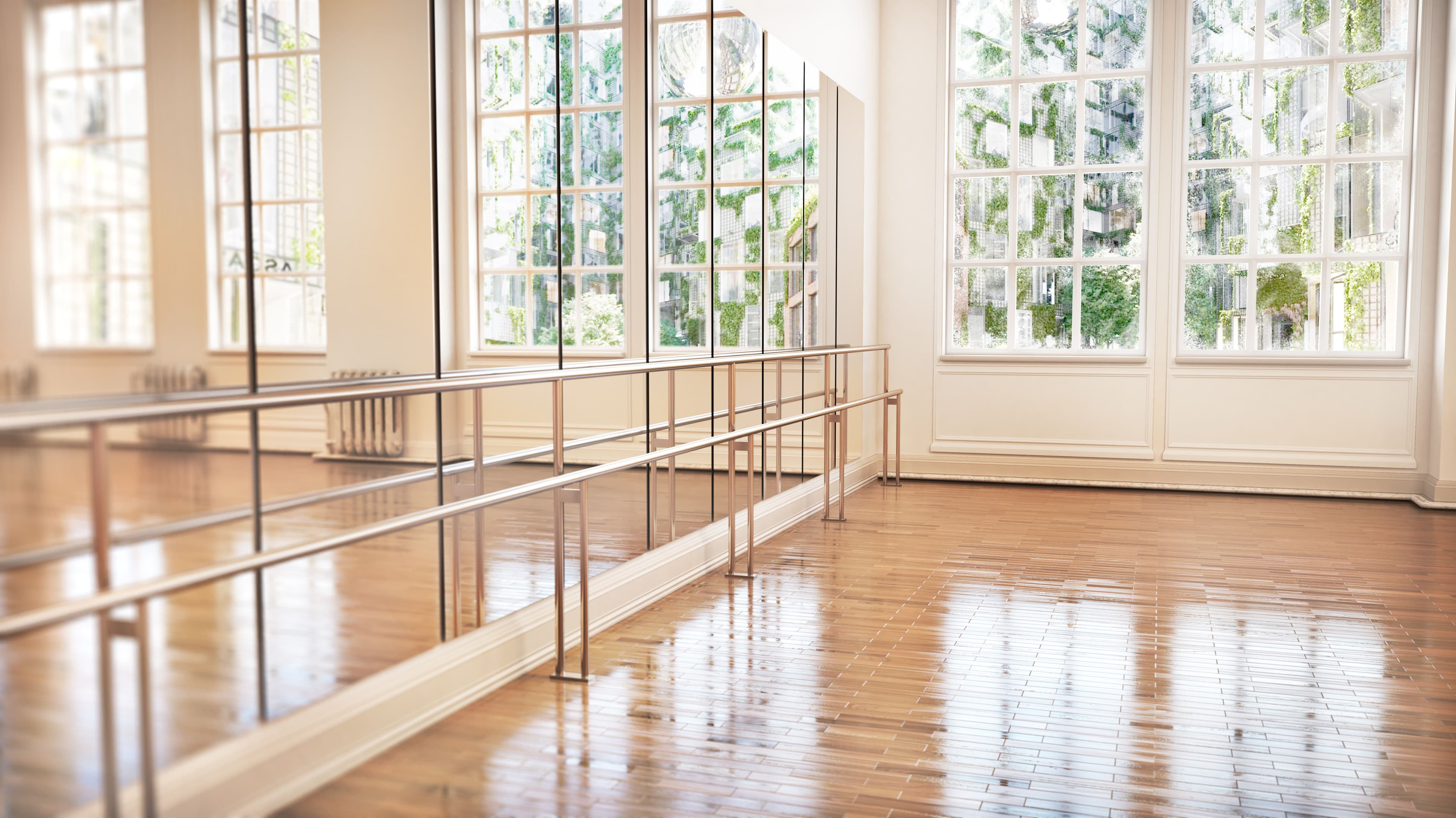 Spacious studio with large windows and reflective mirrors, showcasing custom glass solutions for mirrors, shower doors, and more, featuring natural light and elegant wood flooring.