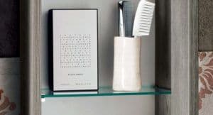 Custom glass shelf displaying a minimalist design with a mirror and grooming items