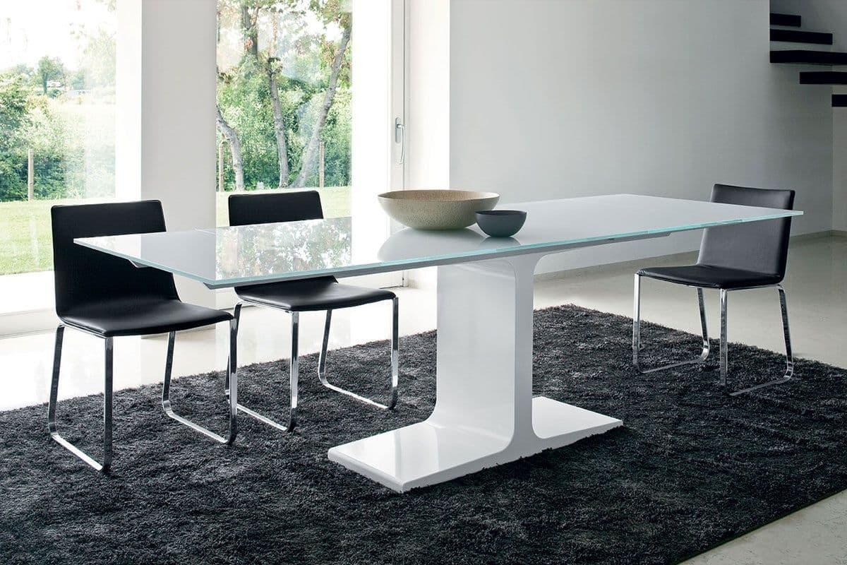 Modern dining room featuring a sleek glass table with a white base, accented by black chairs, showcasing custom glass design.