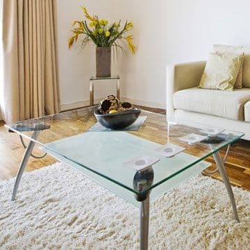 A modern glass coffee table with a beveled edge
