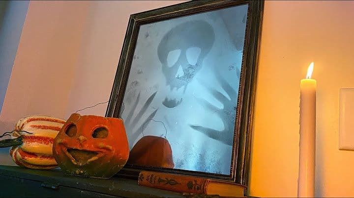 A spooky mirror with a ghostly skull reflection