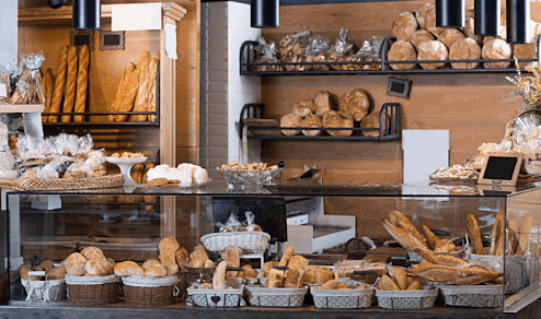 Custom glass display case featuring tempered glass for showcasing freshly baked breads and pastries in a bakery setting.