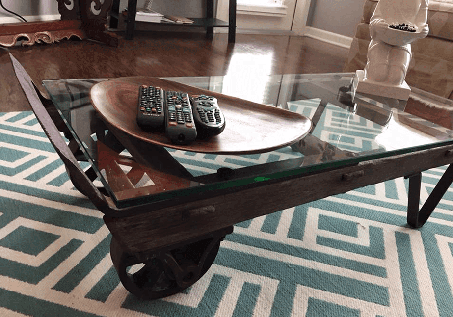 Custom glass table top featuring a tempered glass surface and a unique wooden base