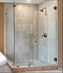 Frameless shower doors featuring custom tempered glass, showcasing a sleek design with beveled glass edges.