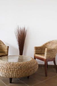 Stylish seating area with wicker chairs and a round table featuring a custom glass top