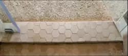 Hexagonal tile shower threshold with custom glass shower doors showcasing tempered glass edge.