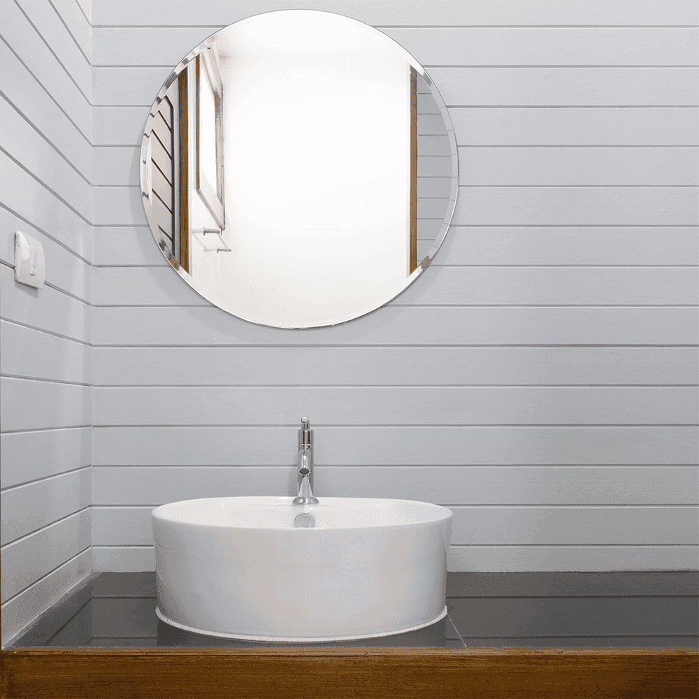 Modern bathroom featuring a sleek round mirror above a stylish sink, emphasizing custom glass design and elegance in bathroom decor.