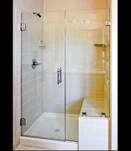 Frameless shower doors made of tempered glass, showcasing a modern design suitable for custom glass applications.