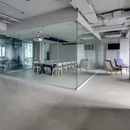 Modern office space featuring custom glass walls, showcasing tempered glass for enhanced design and functionality, ideal for shower doors, table tops, and mirrors.