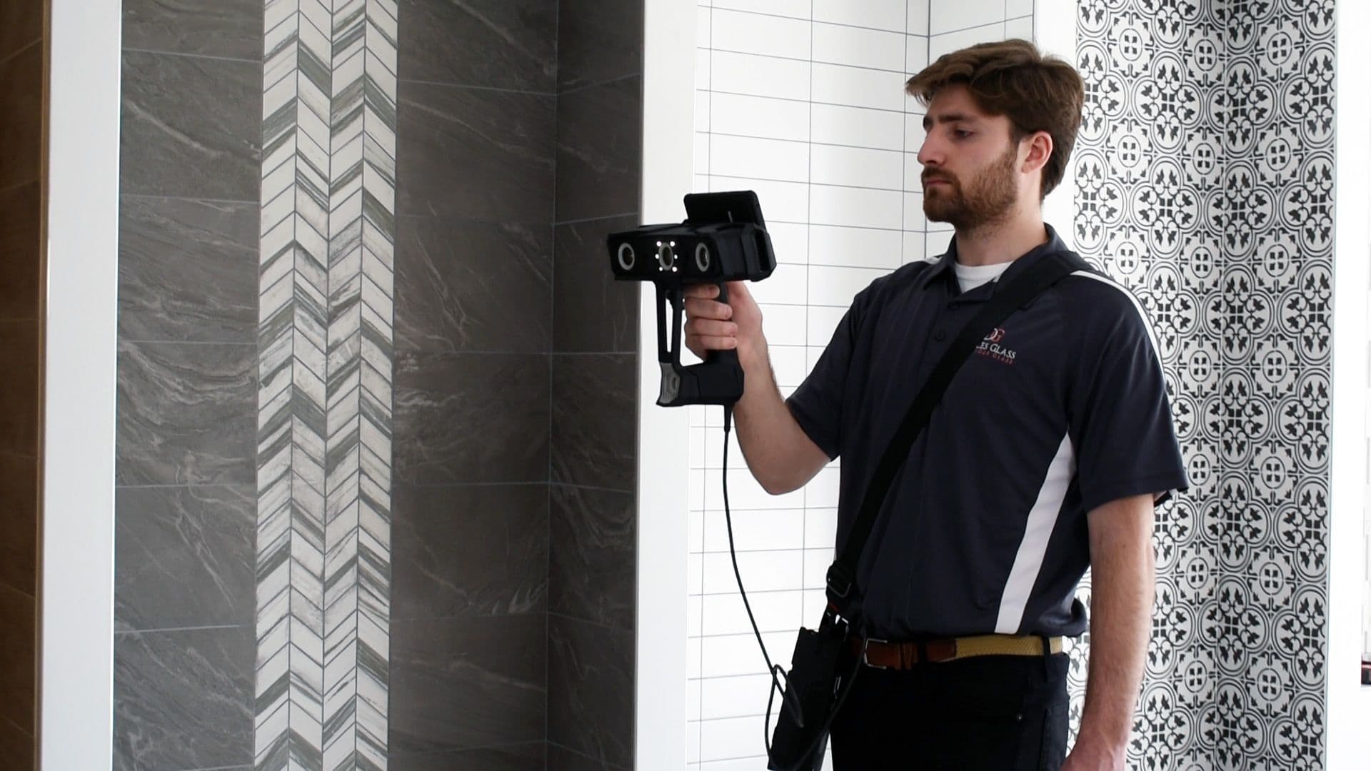 Technician using advanced measuring equipment to assess a custom shower door installation, showcasing a stylish and modern tiled wall design, relevant to custom glass, tempered glass, and shower doors.
