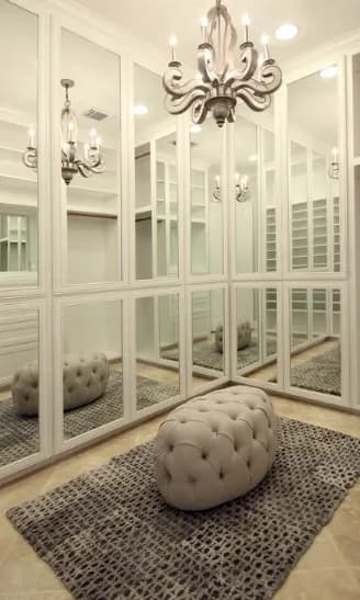 Elegant room featuring custom mirrors reflecting light from a chandelier