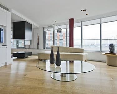 Modern living room featuring a custom glass table top, complemented by sleek decor and ample natural light, ideal for showcasing tempered glass and beveled glass edge designs.