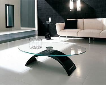 Modern living room featuring a stylish glass tabletop with a black base, surrounded by contemporary furniture, showcasing custom glass design and tempered glass craftsmanship.