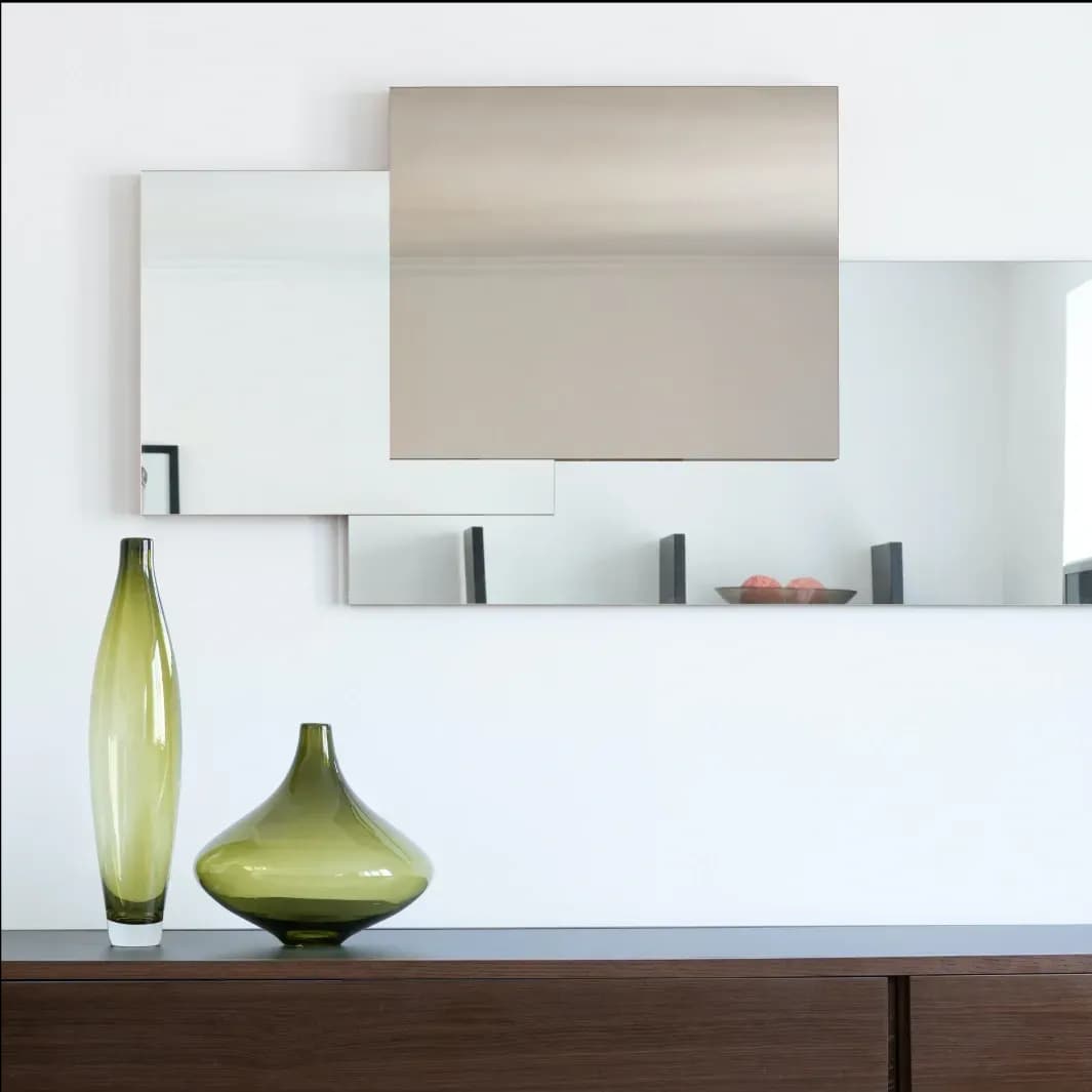 Contemporary mirrors with beveled glass edges above a wooden console featuring decorative vases, ideal for showcasing custom glass and interior decor.