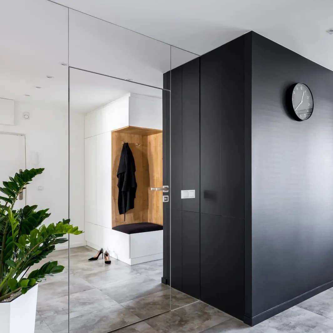 Modern entryway featuring sleek custom glass shower doors, minimalist design, and stylish decor elements, emphasizing tempered glass aesthetics and functionality.