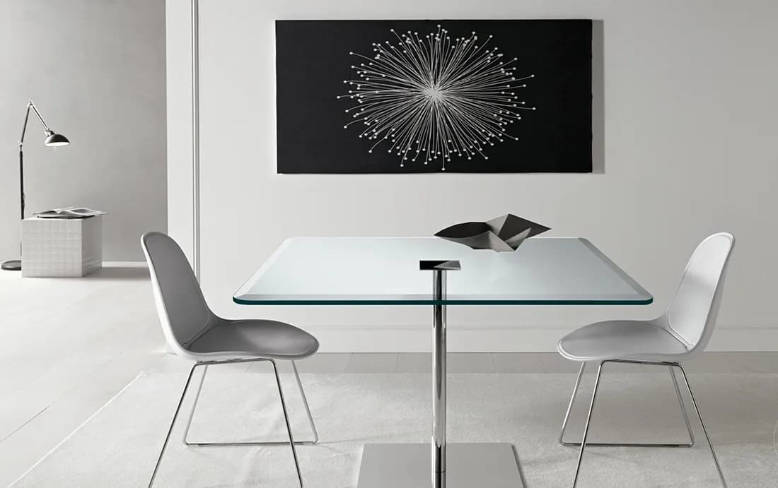 Modern dining area featuring a sleek tempered glass table