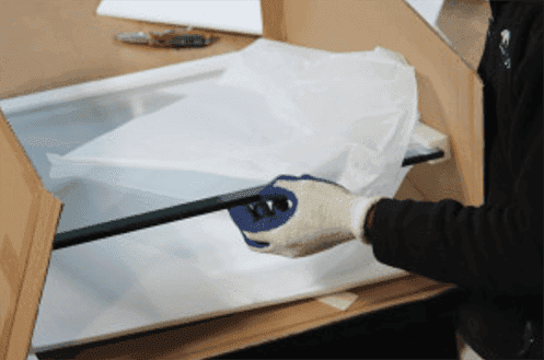 Worker carefully handling custom tempered glass for shower doors