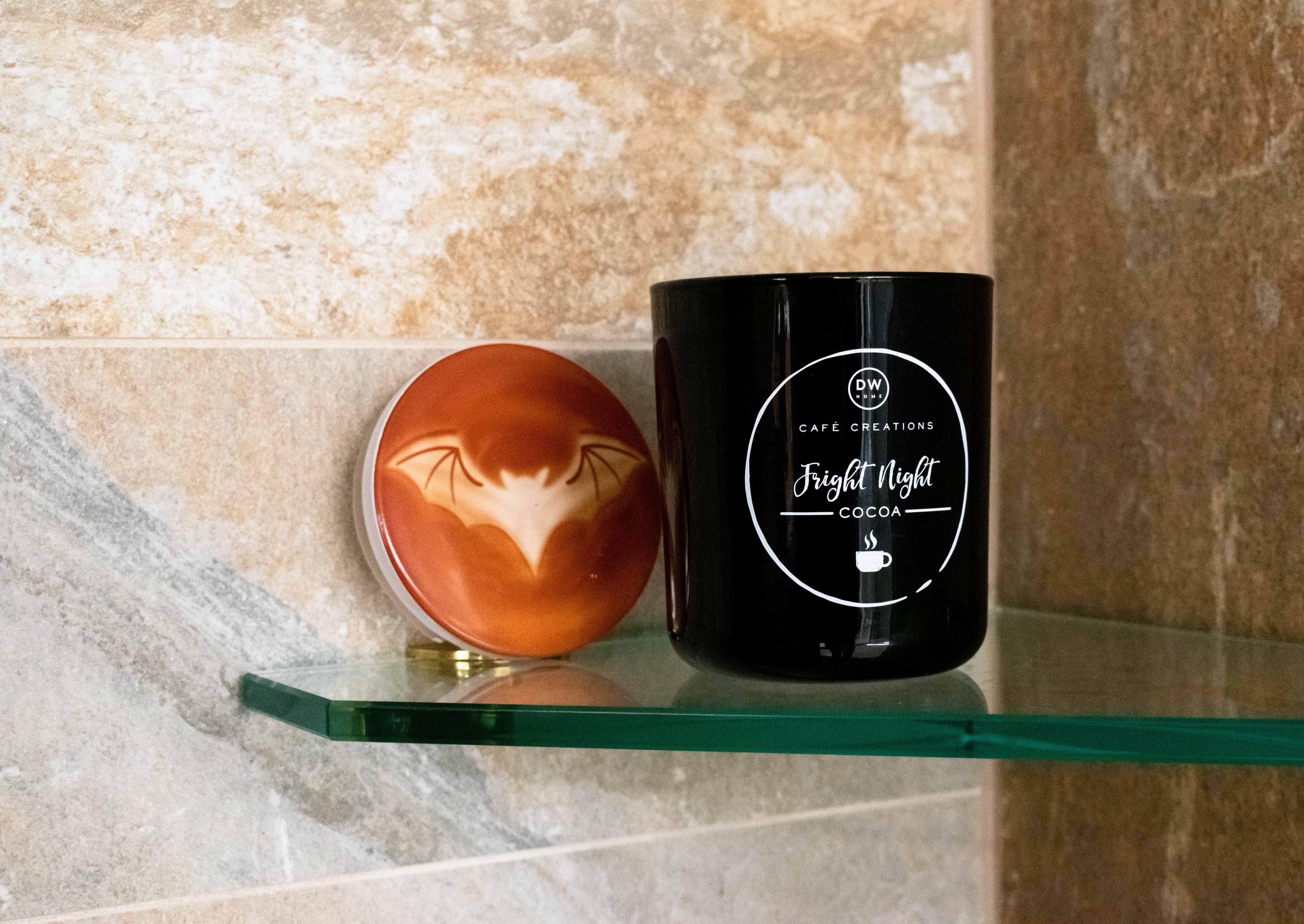 Green tempered glass shelf displaying a decorative container and a mug, highlighting custom glass solutions for shower doors and mirrors.