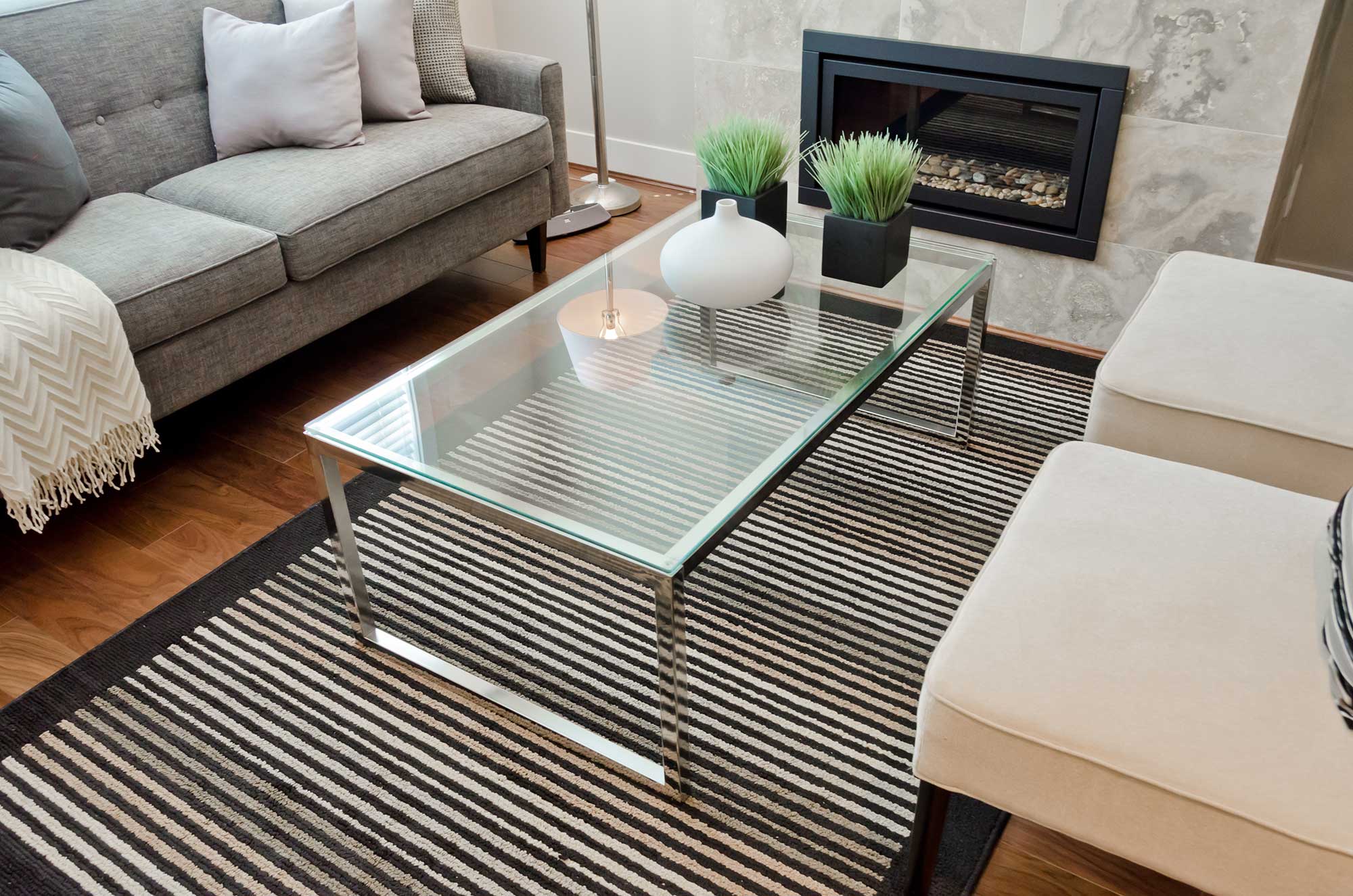 Modern living room featuring a sleek glass coffee table with a tempered glass top, surrounded by decorative elements, highlighting custom glass design and elegance.