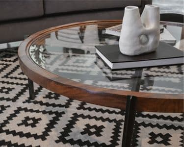 Custom glass tabletop with beveled edge, elegantly designed, showcasing a modern decor style, complementing the surrounding furnishings.