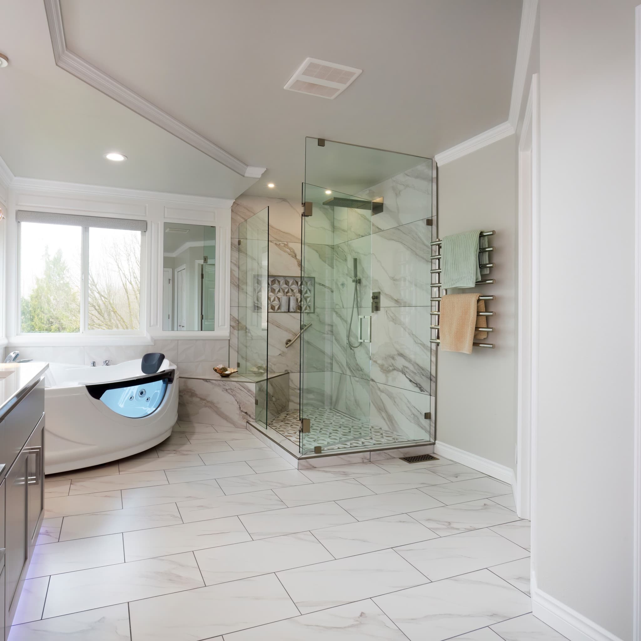 Luxurious bathroom featuring a frameless glass shower enclosure with marble walls