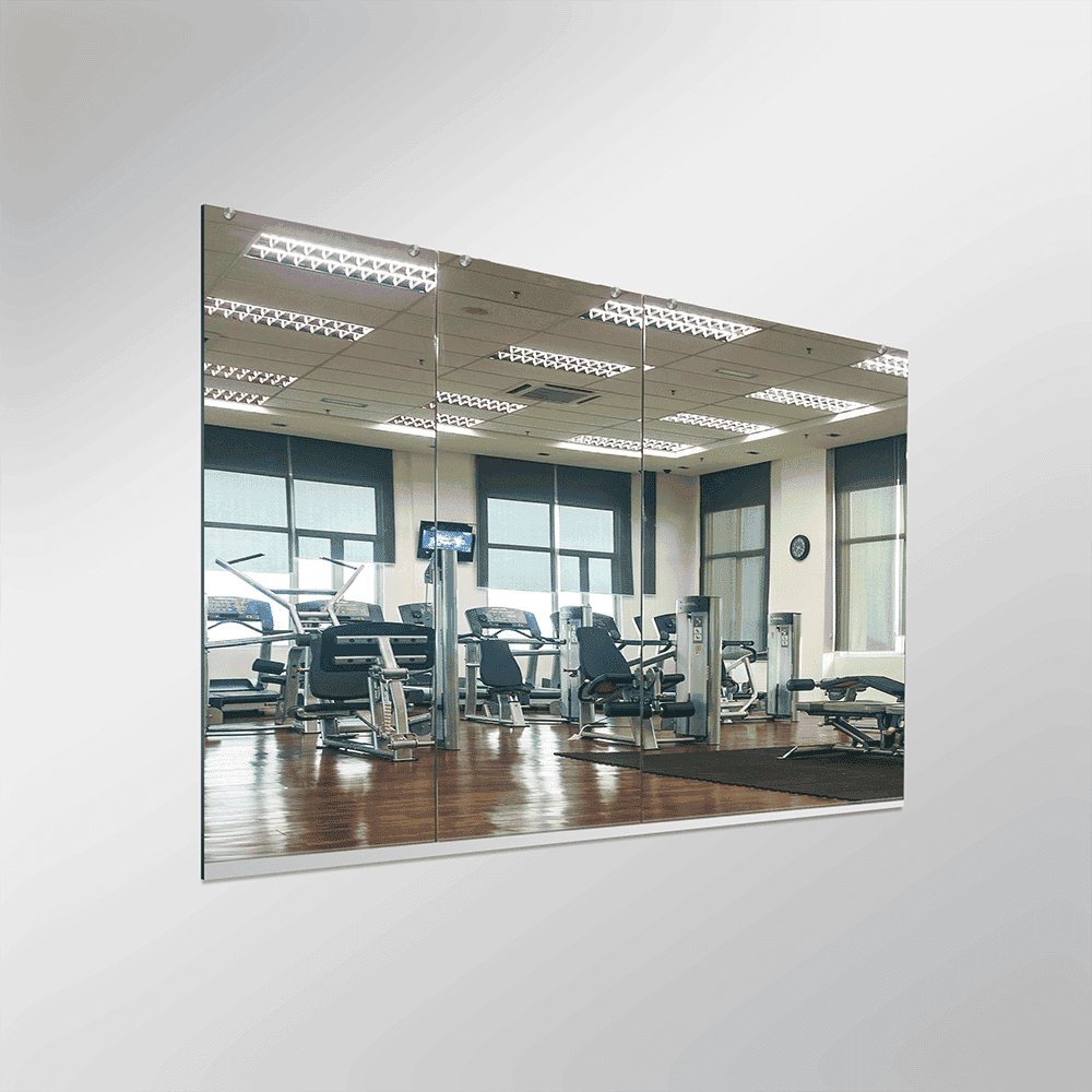Custom glass mirror installation in a gym, showcasing clear, high-quality tempered glass for enhanced durability and style. Perfect for shower doors and fitness spaces.