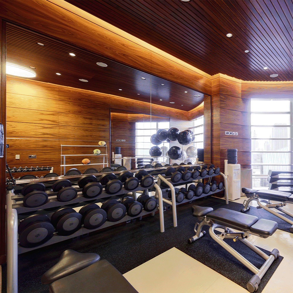 Modern gym interior featuring a full-length mirror, emphasizing custom glass design, with a focus on functional aesthetics and a clean, professional environment.