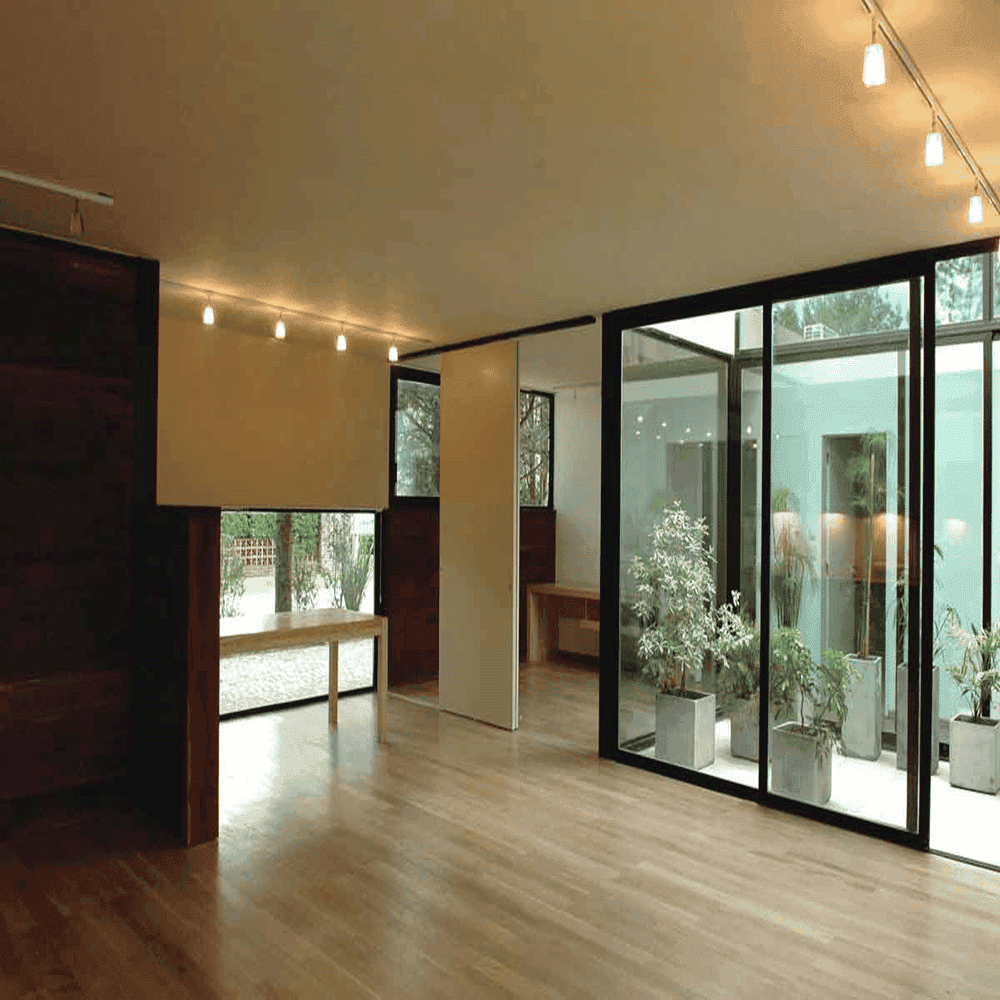 Modern interior featuring large glass panels, showcasing custom glass solutions that enhance natural light and space, ideal for shower doors, table tops, and mirrors with a sleek design.