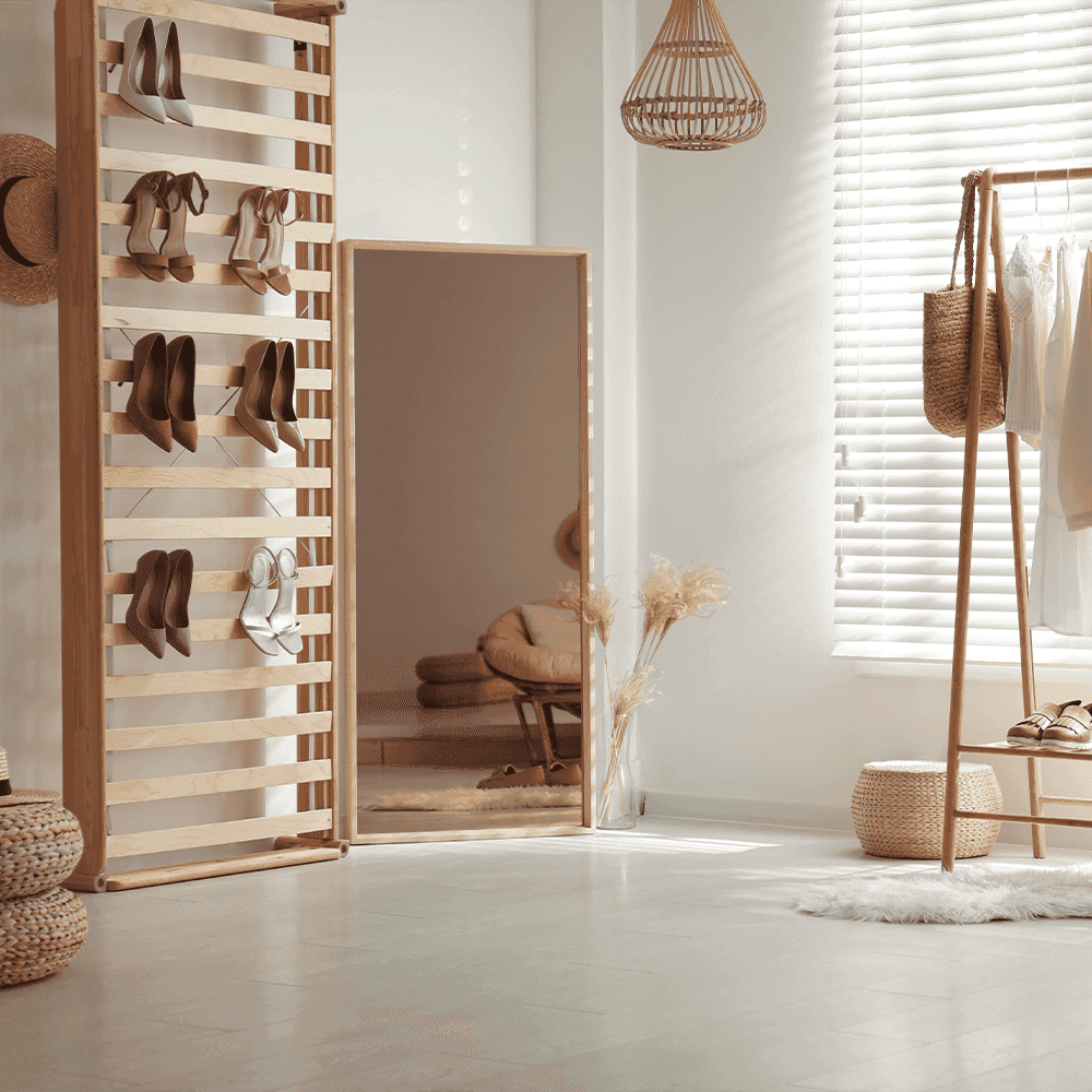 Modern interior with a large mirror, showcasing custom glass design elements, complemented by stylish shoe storage and decor, reflecting a blend of functionality and aesthetics.