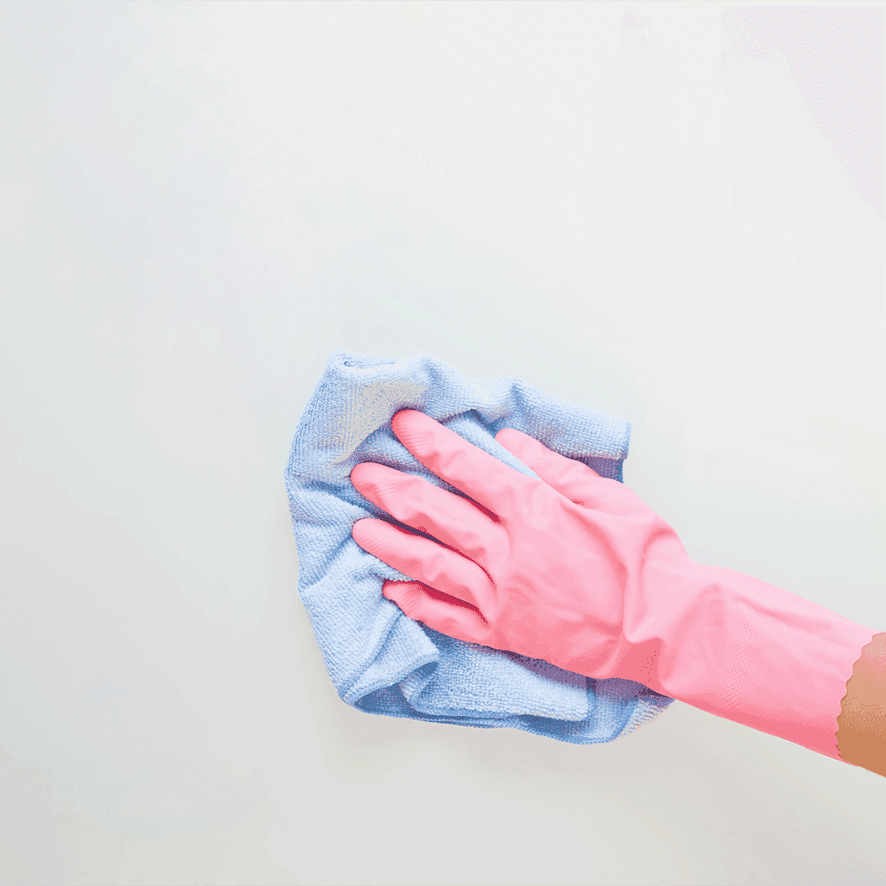 Person cleaning a surface with a microfiber cloth