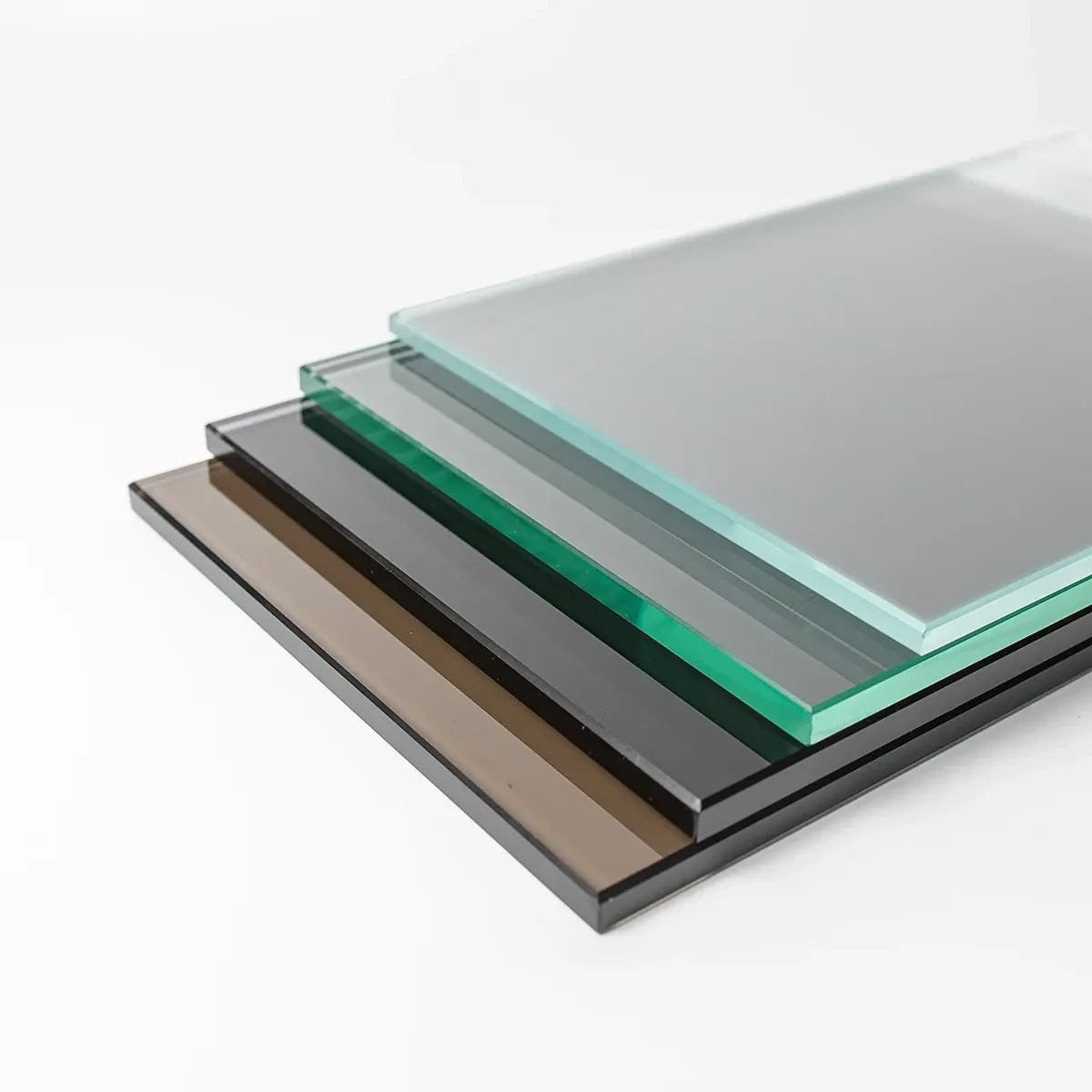 A stack of four glass panel samples showing different finishes, with a translucent frosted glass panel on top of clear, grey, and bronze-tinted glass.