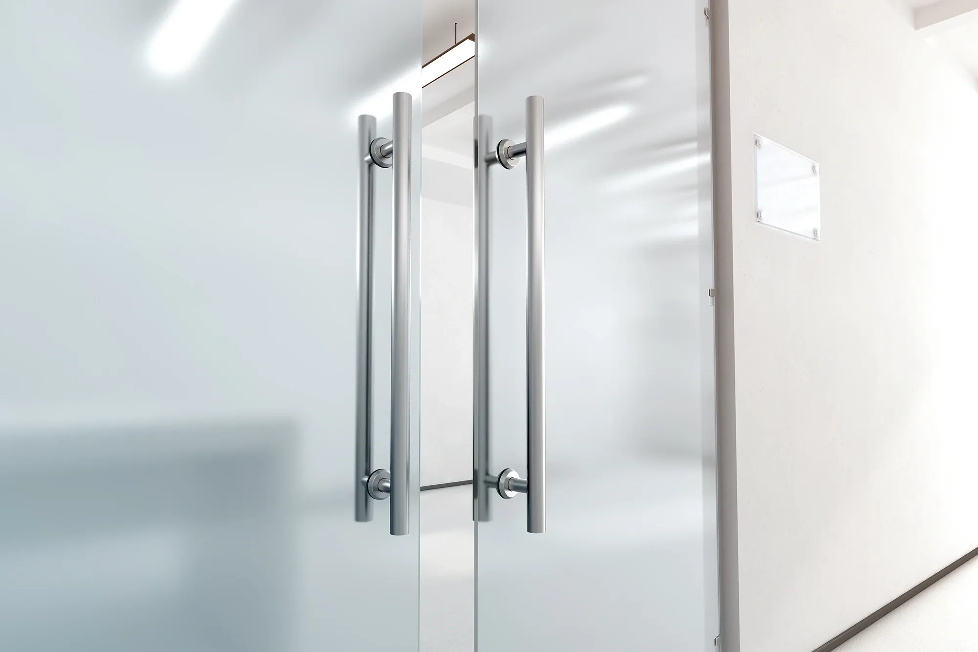 A close-up of modern frosted glass double doors featuring long, brushed stainless steel pull handles in a professional office setting.