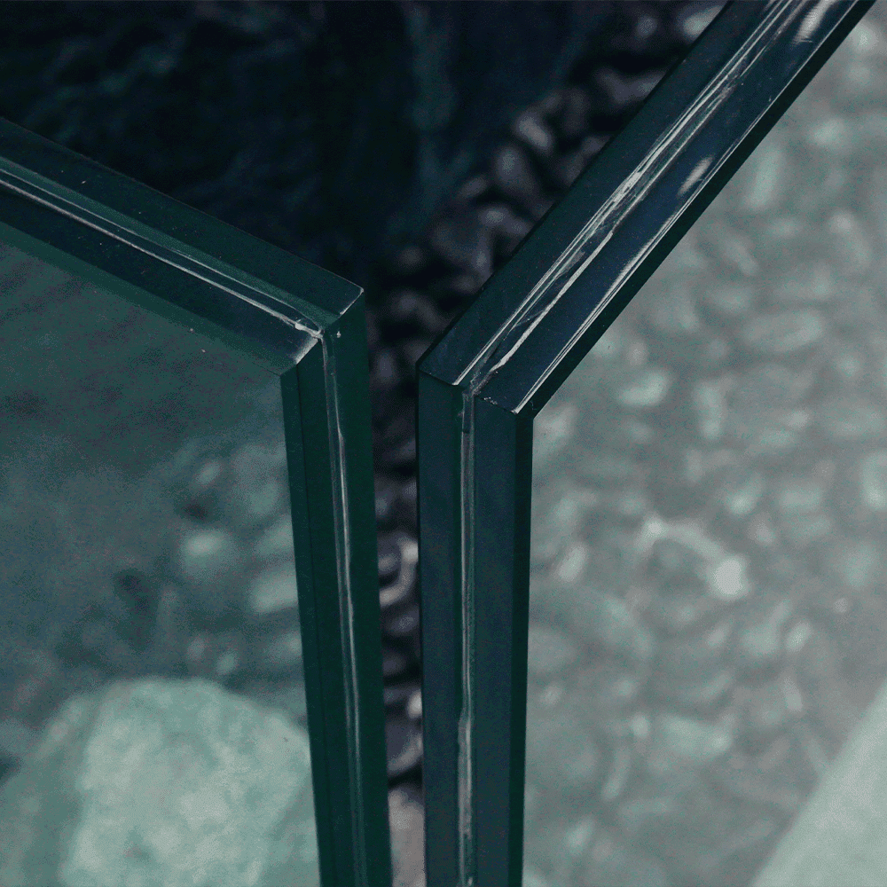 Close-up of custom glass shower doors with a beveled glass edge, showcasing high-quality tempered glass craftsmanship and design.