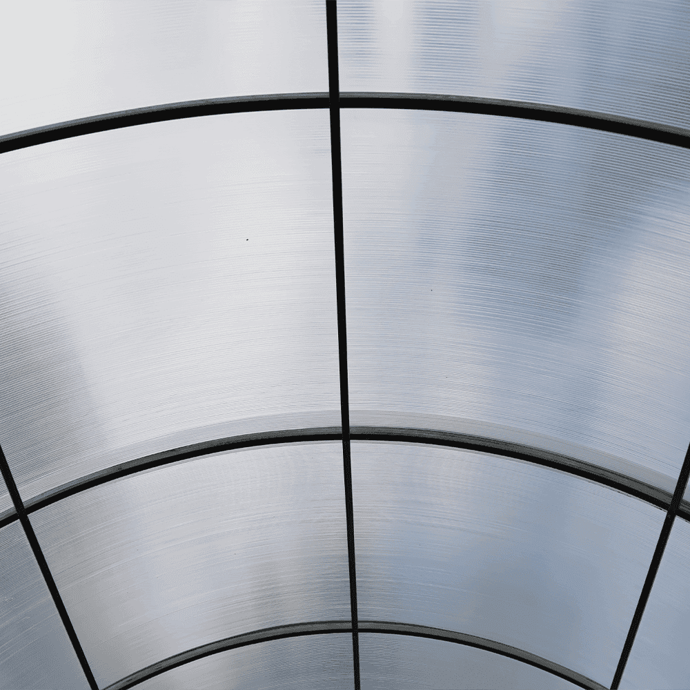 Curved overhead view of tempered glass panels, showcasing custom glass design suitable for shower doors, table tops, and mirrors with a sleek beveled glass edge.