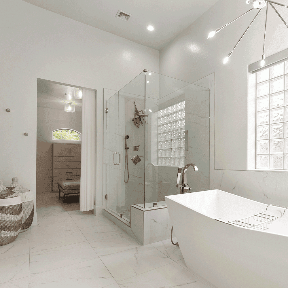 modern bathroom featuring clear tempered glass shower doors, sleek bathtub, stylish mirrors, and marble tile accents, showcasing custom glass design possibilities.