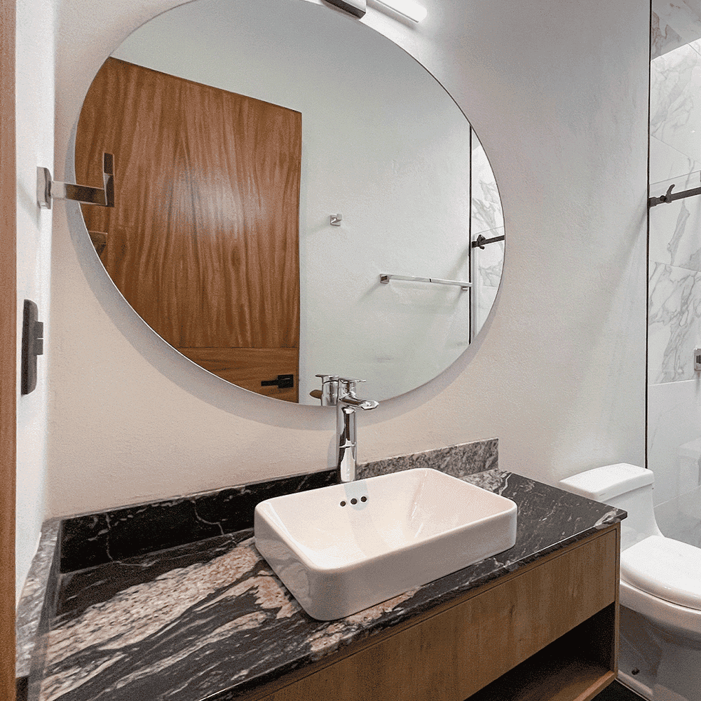 Modern bathroom featuring a large round mirror