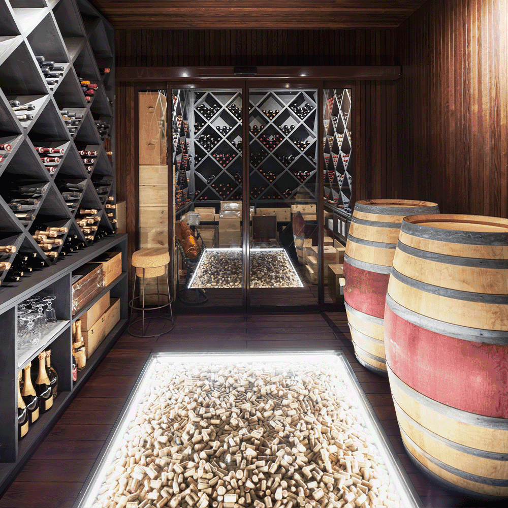 Elegant custom glass wine cellar featuring tempered glass sliding doors and a unique cork floor design
