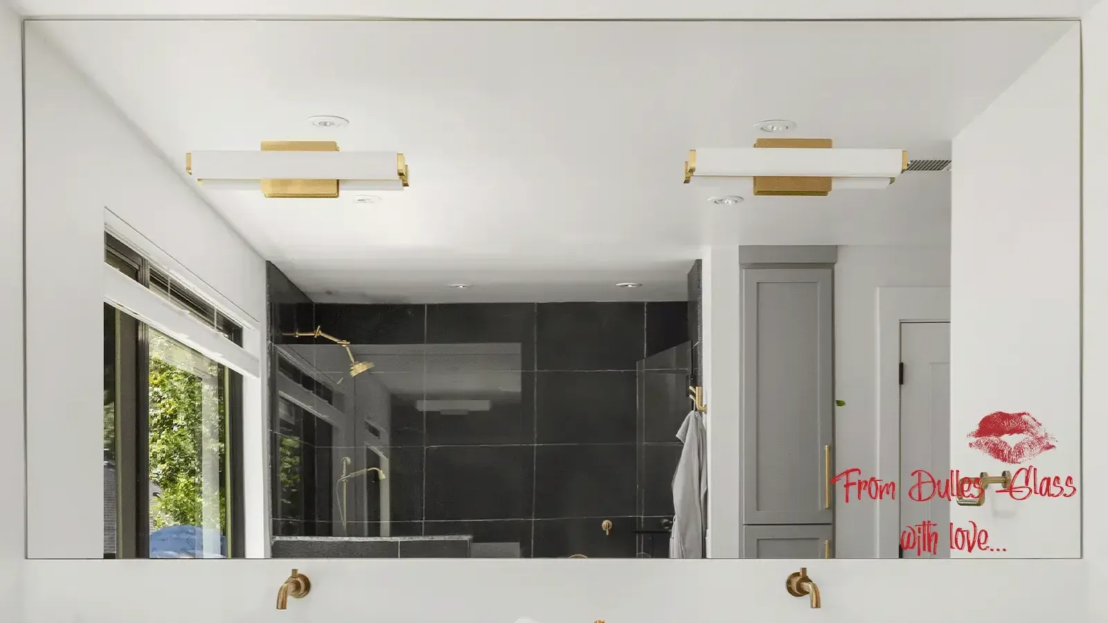 Modern bathroom with a large custom mirror, double vanity, brass fixtures, and a romantic 'From Dulles Glass with love' message on the mirror.