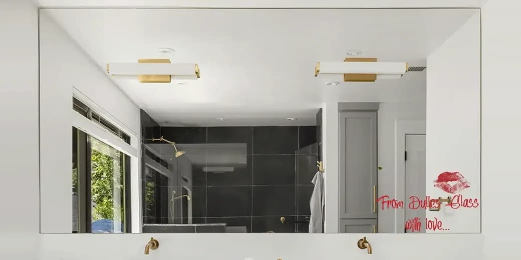 Modern bathroom with a large custom mirror, double vanity, brass fixtures, and a romantic 'From Dulles Glass with love' message on the mirror.