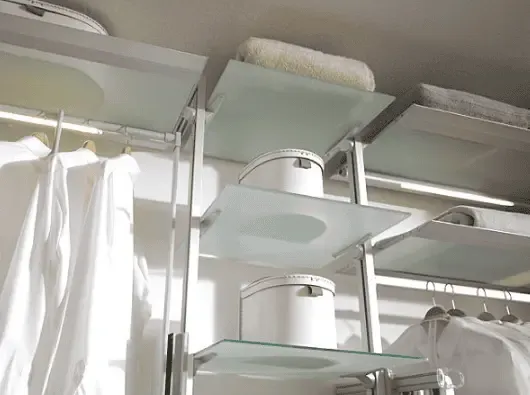 A close-up of a modern open closet system with a metal frame