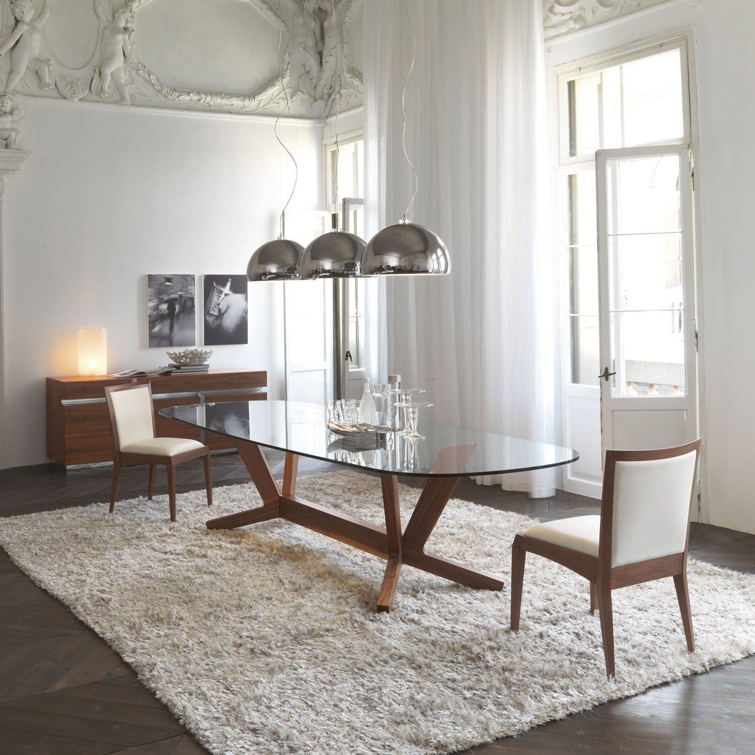 Elegant dining room featuring a custom glass table top with a beveled edge, complemented by modern decor, showcasing a sophisticated and airy atmosphere.